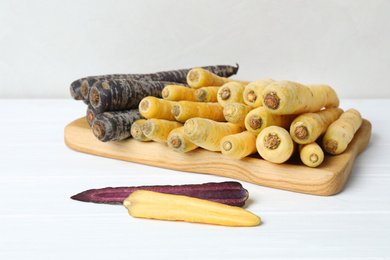 Many different raw carrots on white wooden table