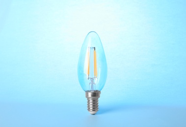 New modern lamp bulb on light blue background