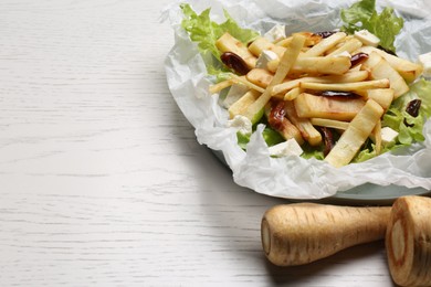 Photo of Delicious parsnip with lettuce, feta cheese and dates on white wooden table, closeup. Space for text