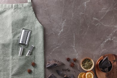 Photo of Clean apron with kitchen tools and different ingredients on brown marble table, flat lay. Space for text