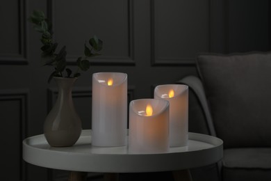 Decorative LED candles on white table in room