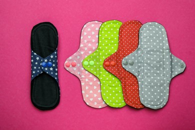 Many reusable cloth menstrual pads on pink background, flat lay