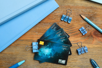 Flat lay composition with credit cards and stationery on wooden background