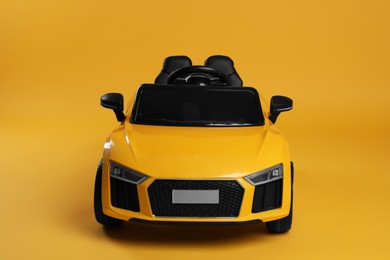 Child's electric toy car on yellow background