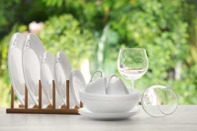 Set of clean dishware on table against blurred background