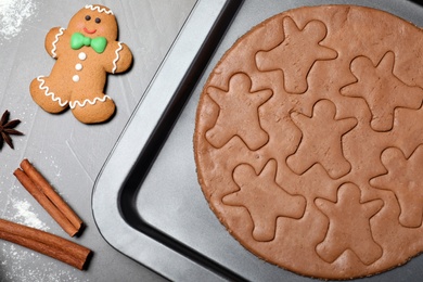 Making homemade gingerbread man cookies on grey table, flat lay