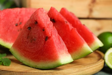 Slices of delicious watermelon and limes on light blue wooden table, closeup