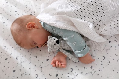 Adorable baby with toy sleeping in bed, above view