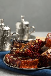 Photo of Tea and Turkish delight served in vintage tea set on grey table, closeup. Space for text