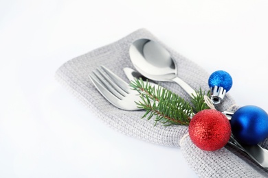 Cutlery, napkin and Christmas decor on white background, closeup. Festive table setting