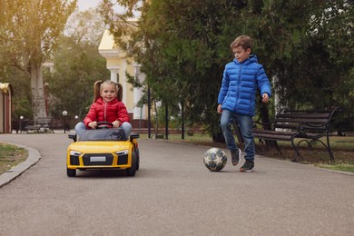 Photo of Cute little children with toy car and soccer ball having fun outdoors