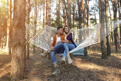 Happy couple resting in hammock outdoors on summer day