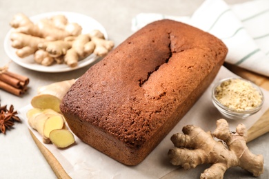 Photo of Delicious gingerbread cake and ingredients on light grey table, above view