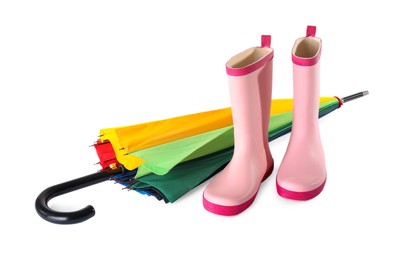 Pink rubber boots and colorful umbrella on white background