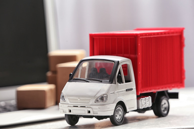 Toy truck near laptop on table. Logistics and wholesale concept