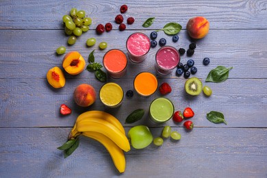Photo of Many different delicious smoothies and ingredients on grey wooden table, flat lay