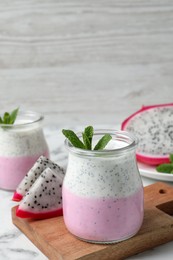 Delicious pitahaya smoothie, fruits and fresh mint on white marble table