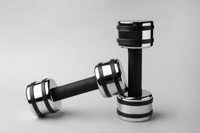 Photo of Two new metal dumbbells on light background