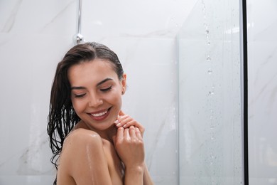Beautiful young woman taking shower at home. Space for text