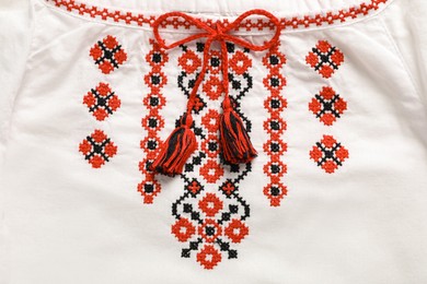 Photo of Beautiful white shirt with red Ukrainian national embroidery, top view