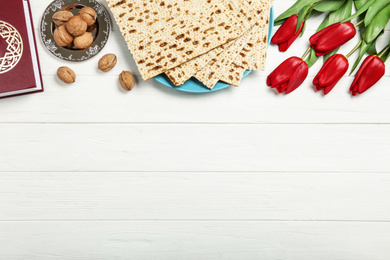 Flat lay composition with matzos on white wooden background, space for text. Passover (Pesach) celebration
