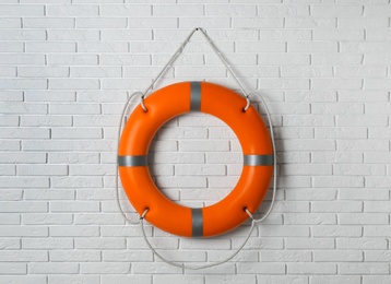 Orange lifebuoy on white brick wall. Rescue equipment