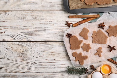 Making Christmas cookies. Flat lay composition with raw dough and ingredients on white wooden table, space for text