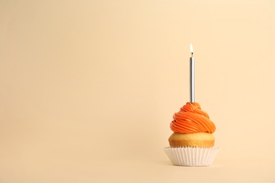 Birthday cupcake with candle on beige background, space for text