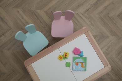 Small table and chairs with bunny ears in children's room, top view