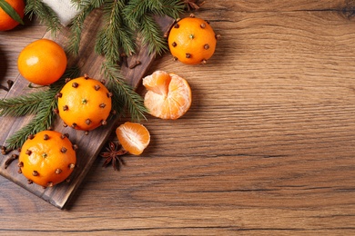 Delicious fresh tangerines and Christmas decor on wooden table, flat lay. Space for text