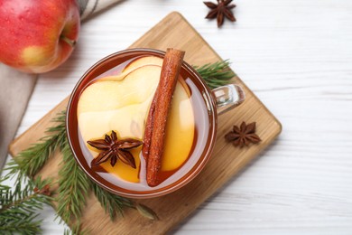 Aromatic hot mulled cider on white wooden table, flat lay