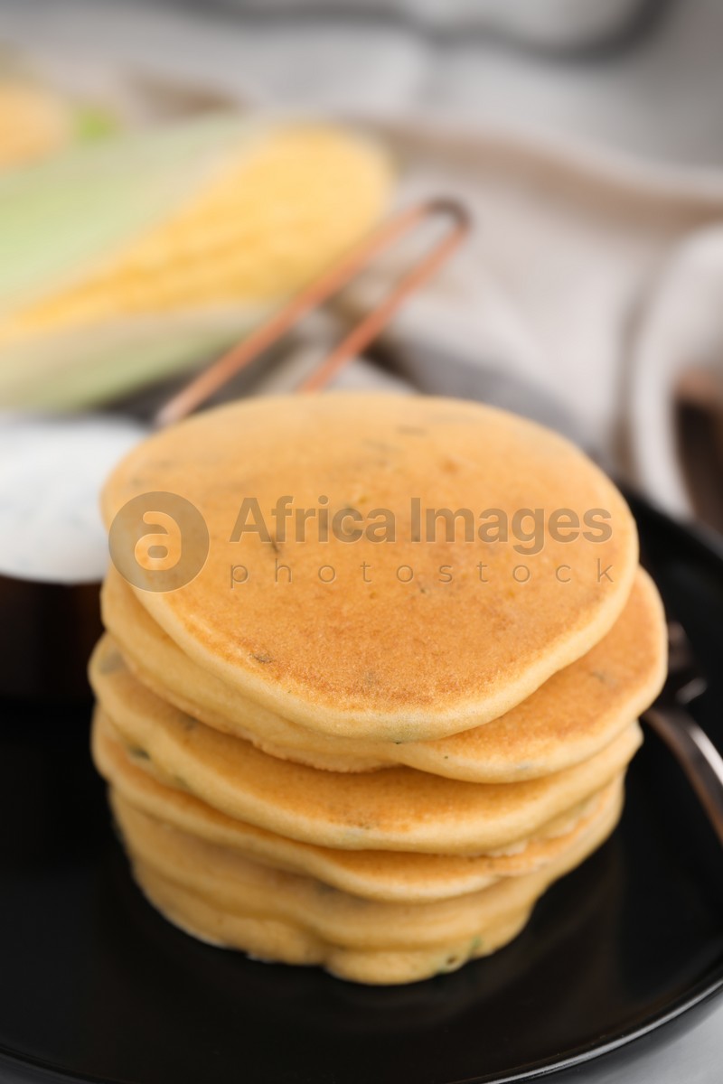 Tasty corn pancakes served on table, closeup
