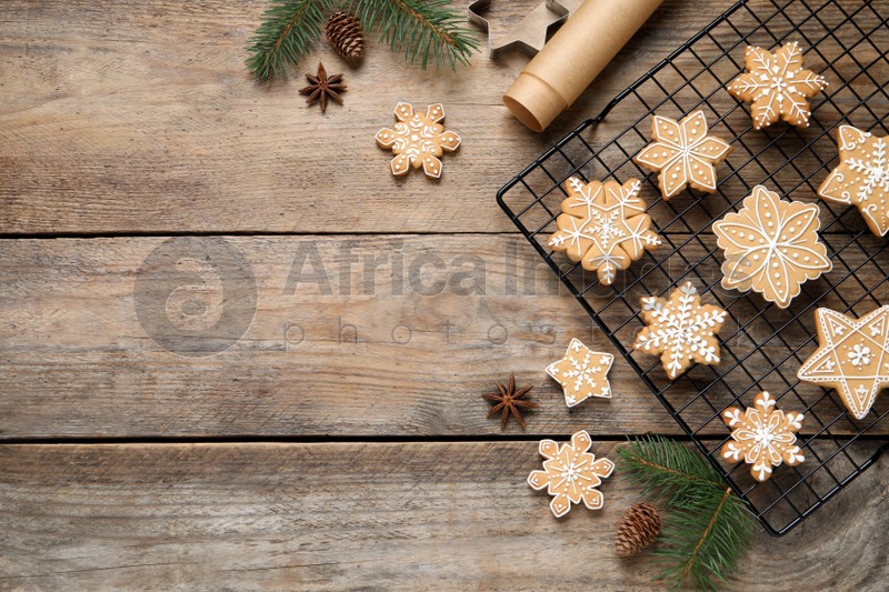 Tasty Christmas cookies and fir branches on wooden table, flat lay. Space for text