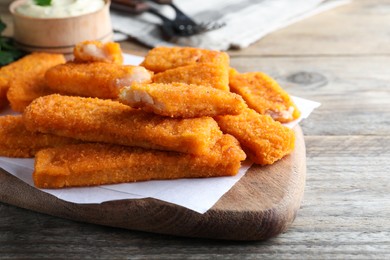 Tasty fresh fish fingers served on wooden table, space for text