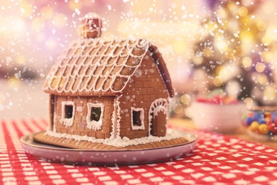 Image of Beautiful gingerbread house decorated with icing on table indoors, space for text