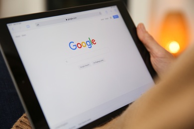 MYKOLAIV, UKRAINE - OCTOBER 31, 2020: Woman using Google search engine on tablet indoors, closeup