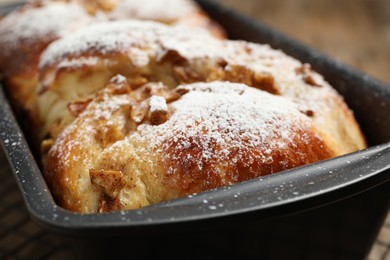 Photo of Delicious yeast dough cake in baking pan, closeup