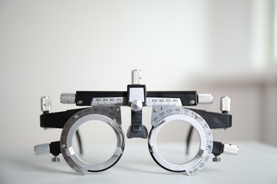 Photo of Trial frame on white table. Ophthalmologist tool