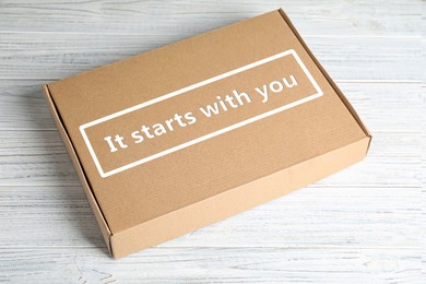 Roles and responsibilities concept. Closed cardboard box with text It stars with you on white wooden table