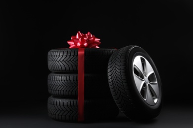 Gift set of wheels with winter tires on black background