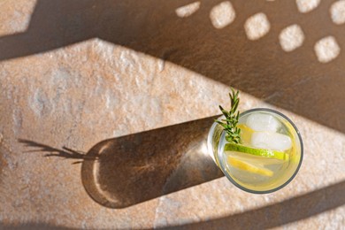 Photo of Summer refreshing lemonade on light brown table, top view. Space for text