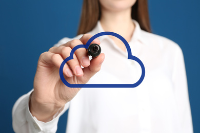Woman pointing at virtual cloud icon on blue background, closeup of hand. Data storage concept