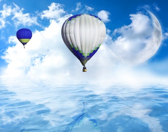 Fantastic dreams. Hot air balloons in blue sky with clouds and crescent moon over sea