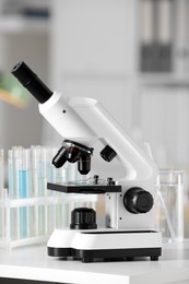Photo of Modern medical microscope on white table in laboratory