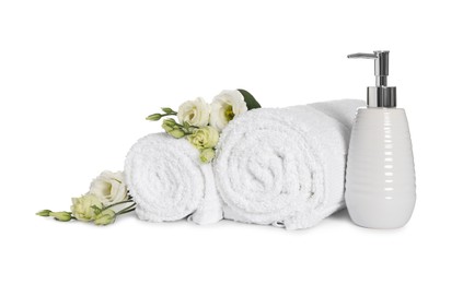 Clean soft towels with flowers and soap dispenser isolated on white
