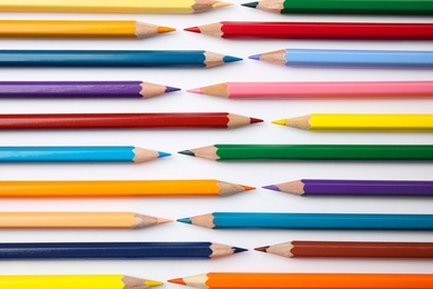 Composition with color pencils on white background, top view