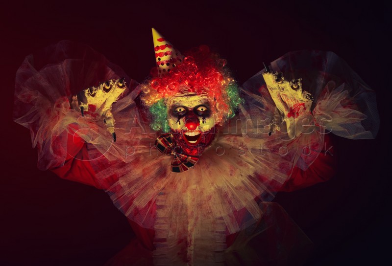 Terrifying clown in darkness. Halloween party costume
