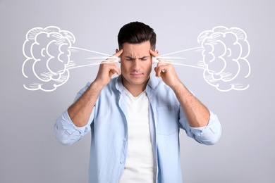 Stressed and upset young man on light grey background