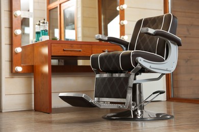 New empty chair near table with mirror in hairdressing salon