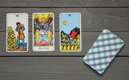 Tarot cards on grey wooden table, flat lay